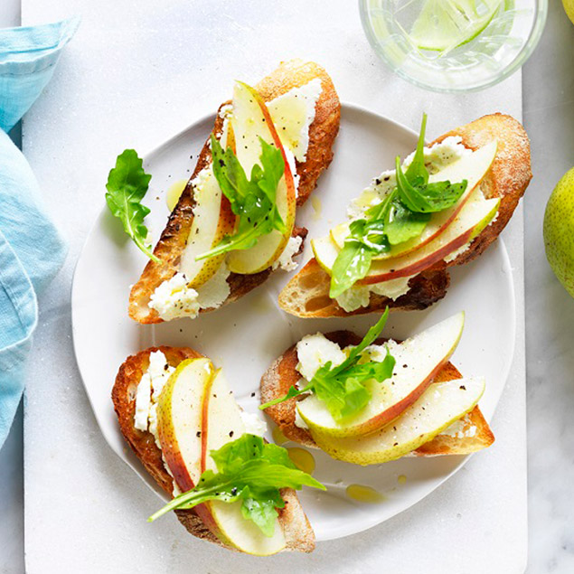 Toasted French baguette slices with ricotta, pear and rocket